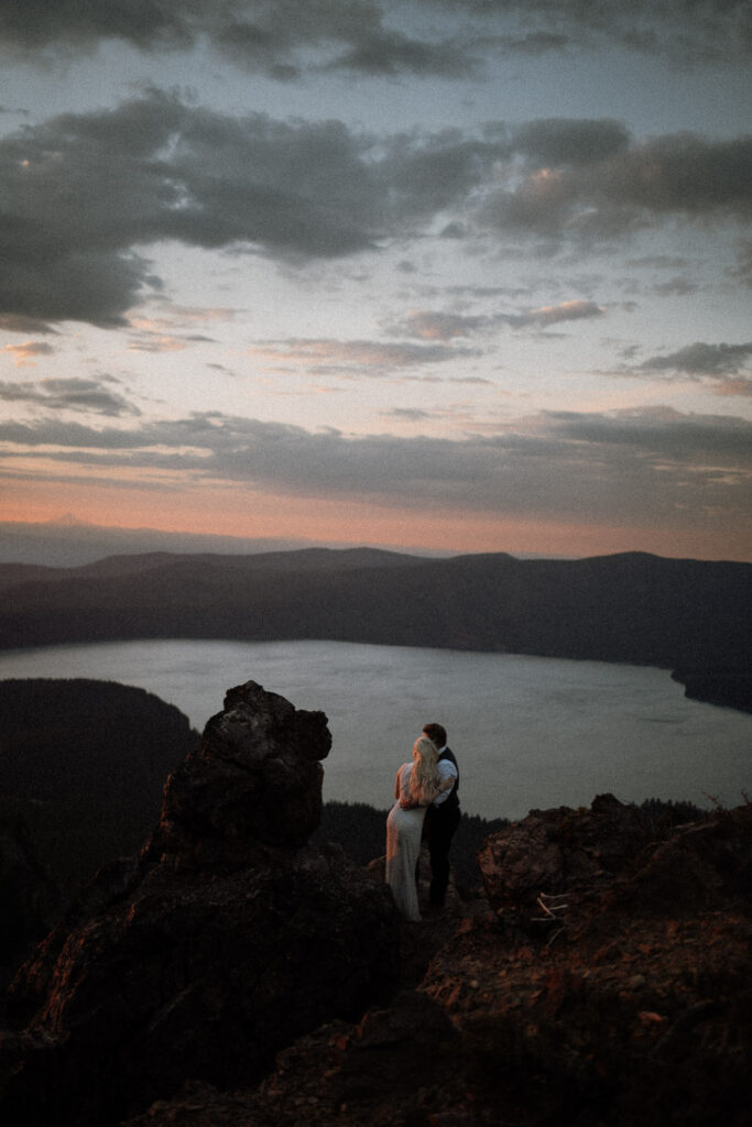 a couple standing on top of a volcano during their oregon wedding