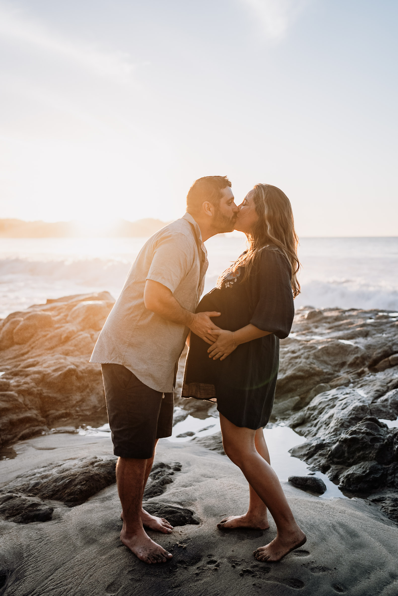 a couple standing on the rocks at Sayulita beach